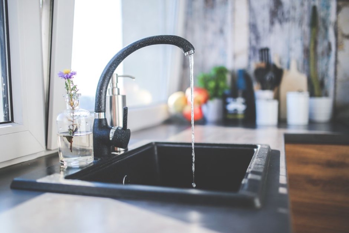 Stainless steel gravity water filter on a kitchen countertop